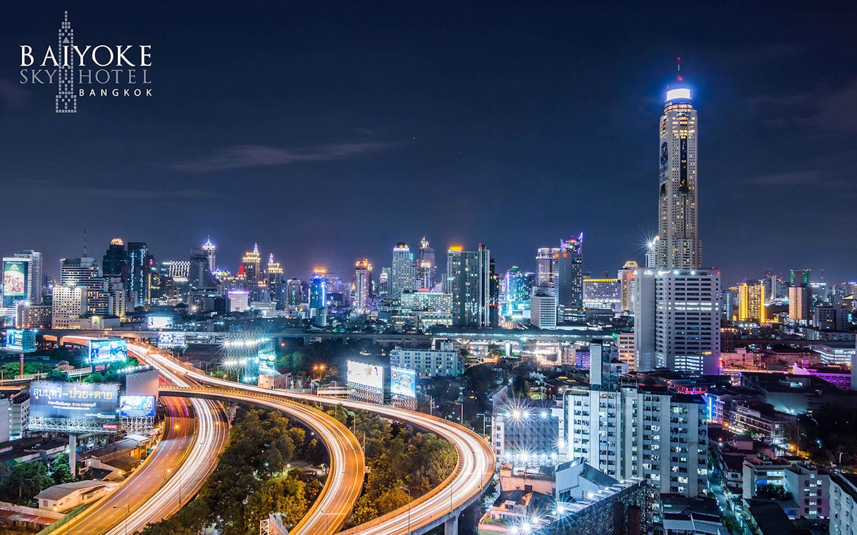 Bangkok skyline at night with Baiyoke Sky Hotel towering above city lights.