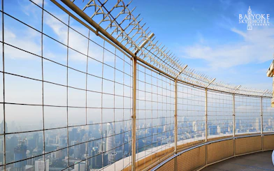 Baiyoke Sky Hotel observatory view of Bangkok skyline through safety fence.