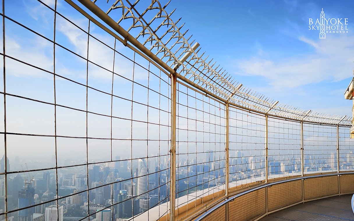 Baiyoke Sky Hotel observatory view of Bangkok skyline through safety fence.