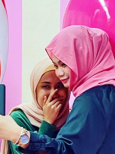 Visitors taking a selfie at the Selfie Museum in Langkawi with colorful art in the background.