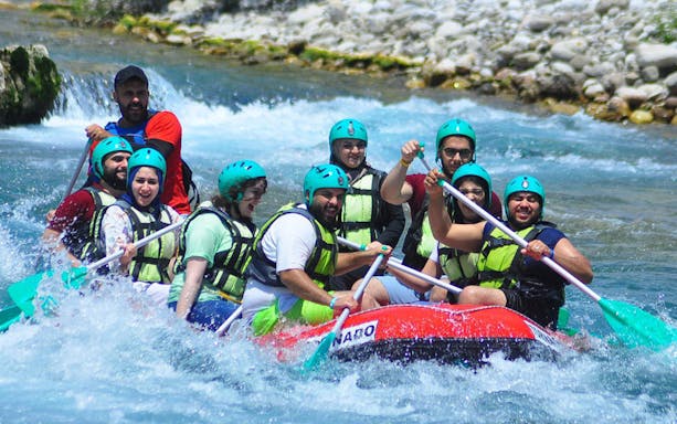 Group rafting on Koprulu Canyon river with helmets and paddles.