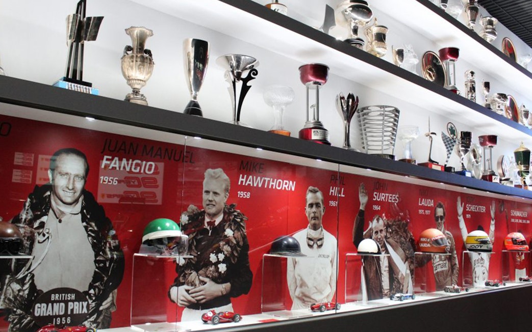 Trophies and racing memorabilia at Ferrari Museum Maranello, featuring famous drivers.