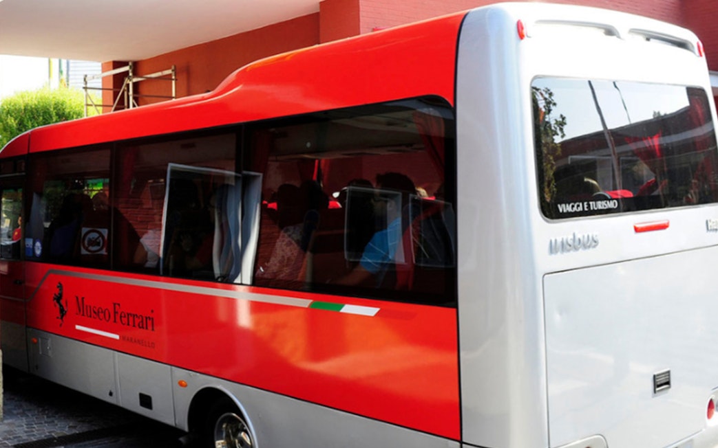Red shuttle bus for Fiorano Track tour and Ferrari Museum Maranello entrance.