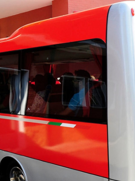 Red shuttle bus for Fiorano Track tour and Ferrari Museum Maranello entrance.