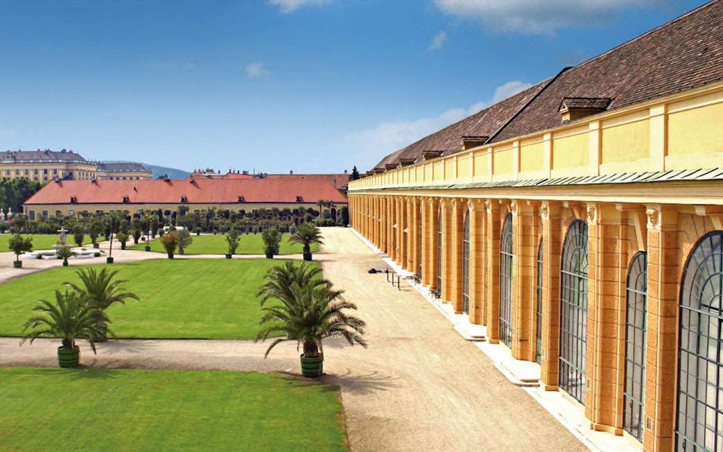 Schönbrunn Palace exterior with gardens and palm trees, Vienna, Austria.