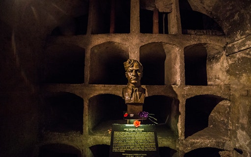 Bust of Jaroslav Švarc in a dimly lit crypt, part of a historical tour in Prague.