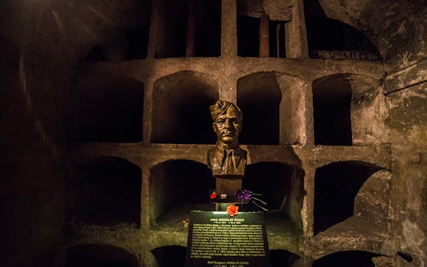 Bust of Jaroslav Švarc in a dimly lit crypt, part of a historical tour in Prague.