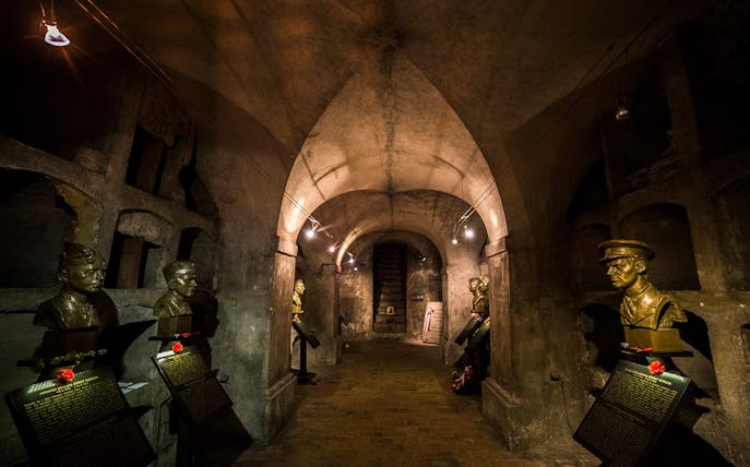 Busts of historical figures in an underground crypt on a guided tour in Prague.