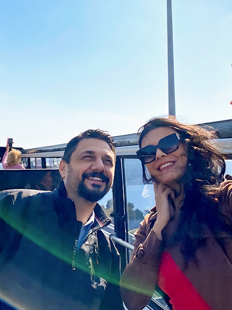 Tourists on Istanbul hop-on hop-off bus with Bosphorus Bridge in background.