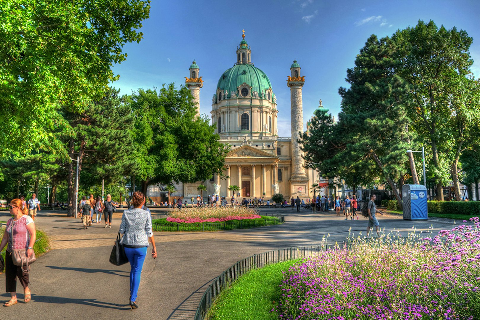 Karlskirche in Vienna with people walking in the garden, location for Vivaldi’s Four Seasons concert.