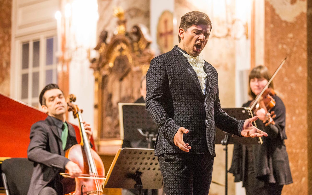 Musicians performing Vivaldi's Four Seasons at Karlskirche, Vienna, with audience in view.