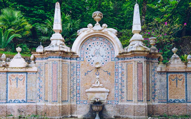 Ornate stone fountain with mosaic details at Quinta da Regaleira, Sintra.