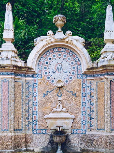 Ornate stone fountain with mosaic details at Quinta da Regaleira, Sintra.