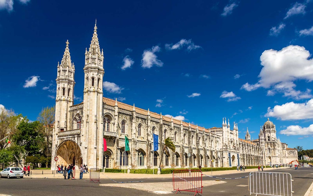 Jerónimos Monastery facade in Lisbon under a clear blue sky.