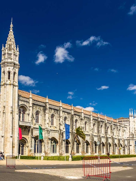 Jerónimos Monastery facade in Lisbon under a clear blue sky.