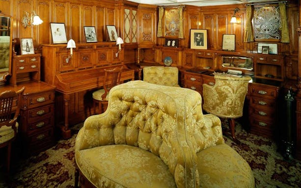 Luxurious wood-paneled room with ornate furniture at Maritime Museum Lisbon.