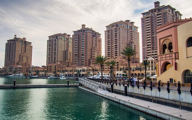 Doha skyline with waterfront promenade and high-rise buildings on the Doha Delights City Tour.