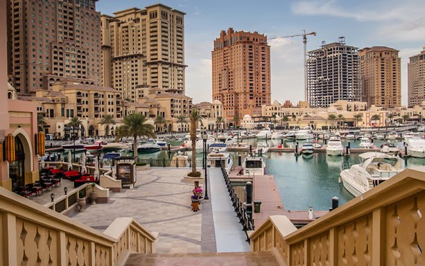 Marina view with yachts and high-rise buildings in Doha, Qatar.