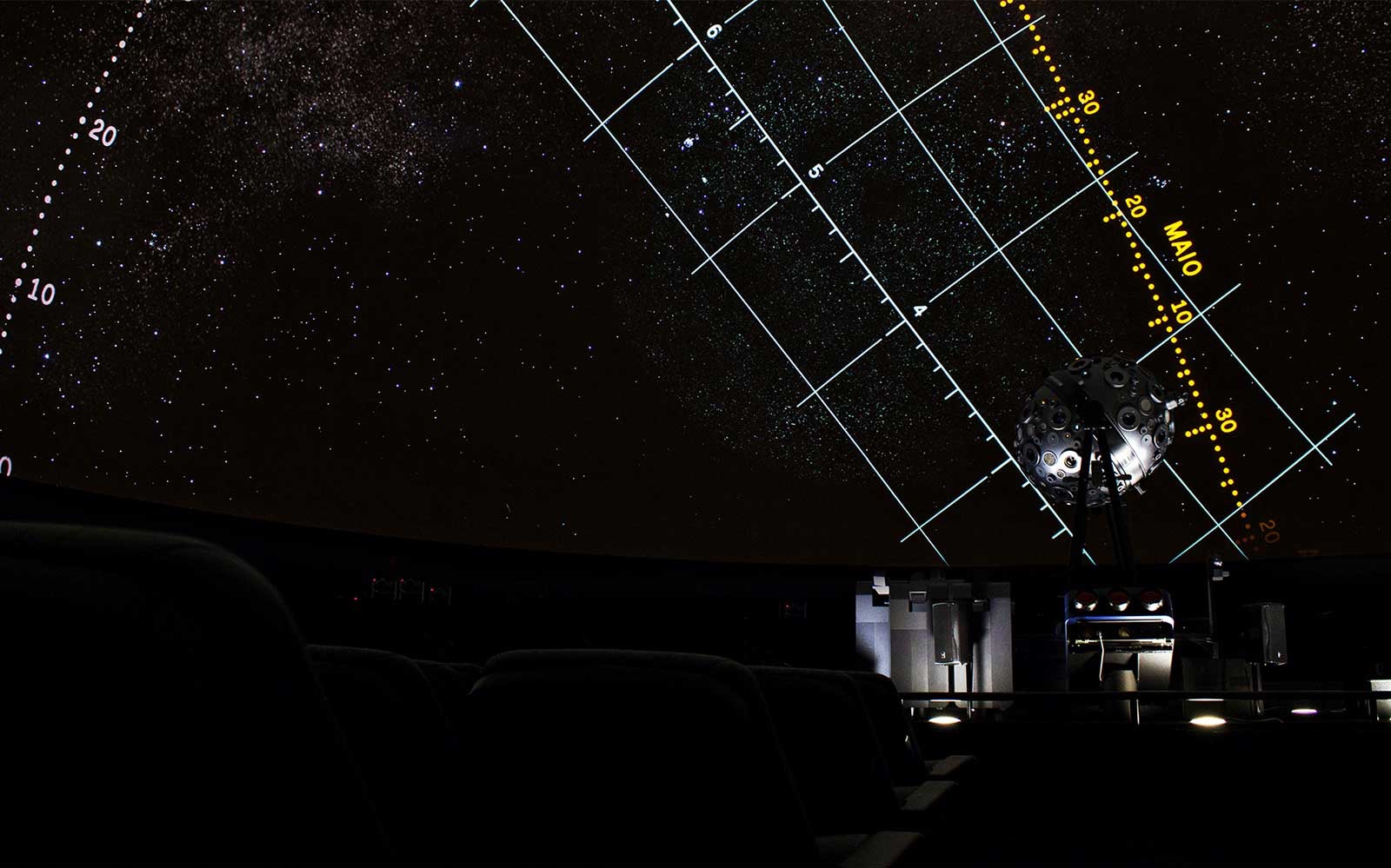 Starry projection inside Navy Planetarium with celestial grid lines.