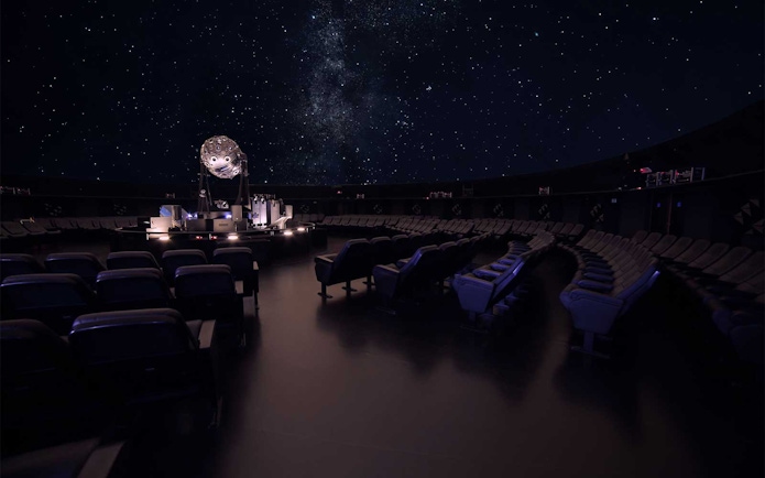 Navy Planetarium interior with starry sky projection and seating arrangement.