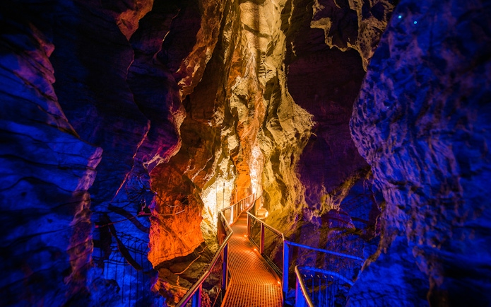Walkway through illuminated Waitomo Glowworm Caves, New Zealand.