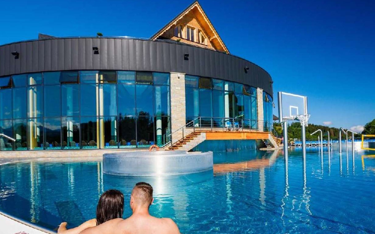 Couple relaxing in outdoor pool at Chocholow Thermal Baths, Poland.
