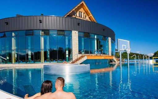 Couple relaxing in outdoor pool at Chocholow Thermal Baths, Poland.