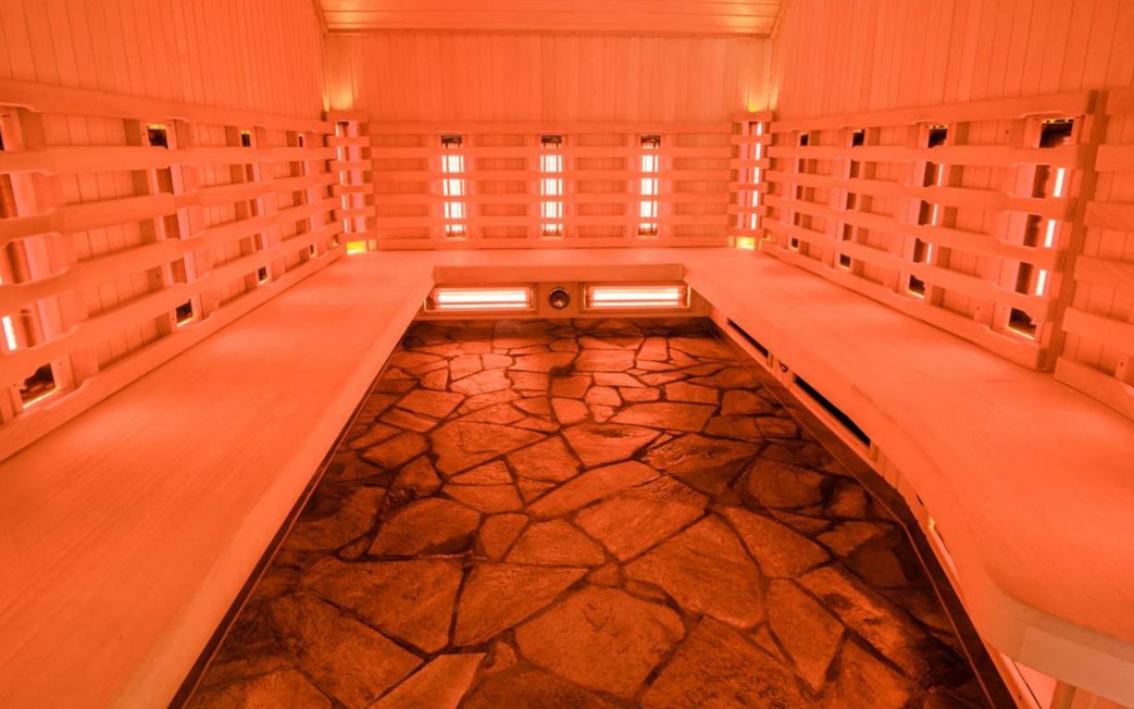 Chocholow Thermal Baths’ Saunarium interior with stone floor and wooden benches.