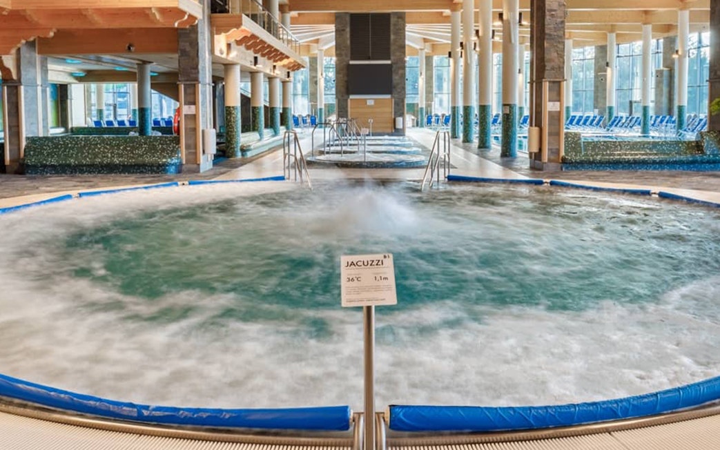 Chocholow Thermal Baths Saunarium jacuzzi with bubbling water and seating area.