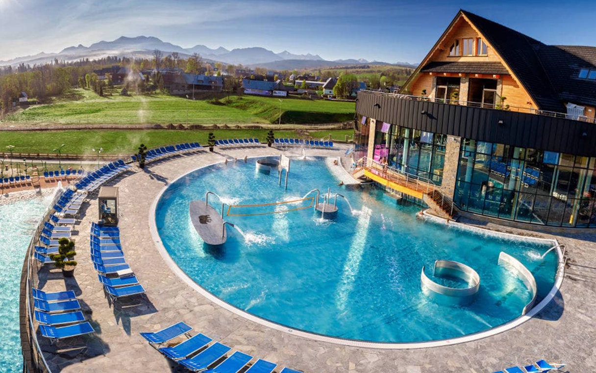 Outdoor pool at Chocholow Thermal Baths with mountain view in Poland.