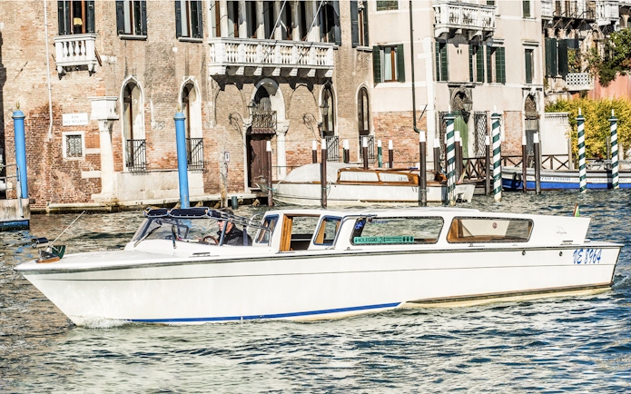 Private water taxi on Venice canal near historic buildings.