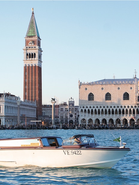 Water taxi cruising near Doge's Palace and St. Mark's Campanile in Venice.