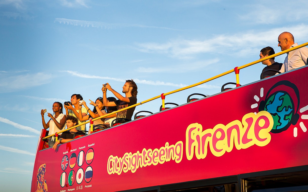 Tourists on an open-top bus during a Florence sightseeing tour.