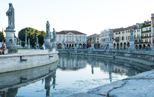 Prato della Valle with statues and canal in Padua, Italy, on a sightseeing bus tour.