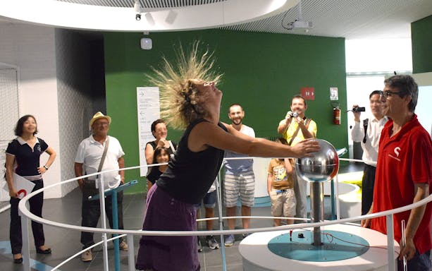 Visitor experiencing static electricity at Città della Scienza, Naples.