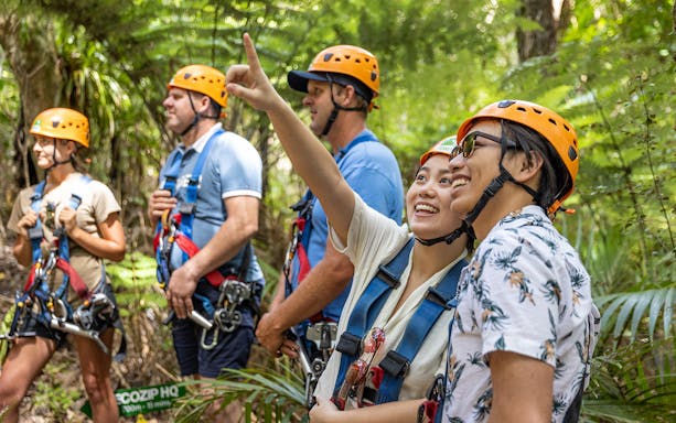 Couple enjoying a guided forest walk with safety gear and helmets.