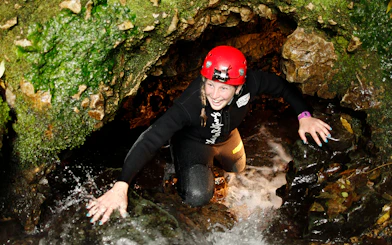Adventurer exploring Waitomo cave during Black Water Rafting tour.