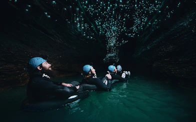 Adventurers black water rafting under glowworms in Waitomo cave.