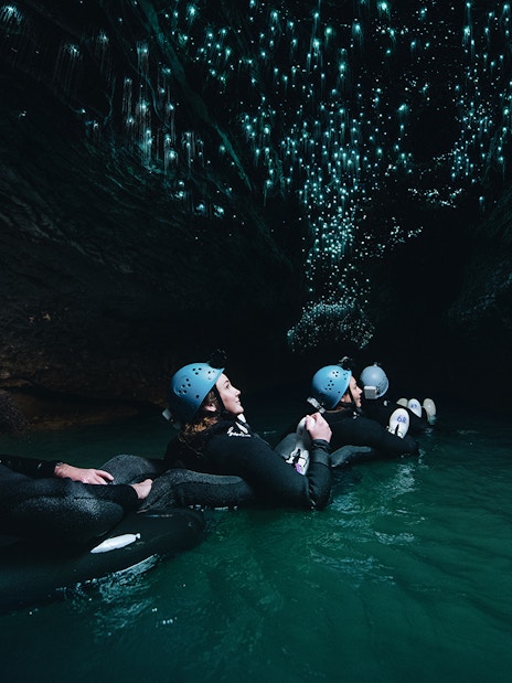 Adventurers black water rafting under glowworms in Waitomo cave.
