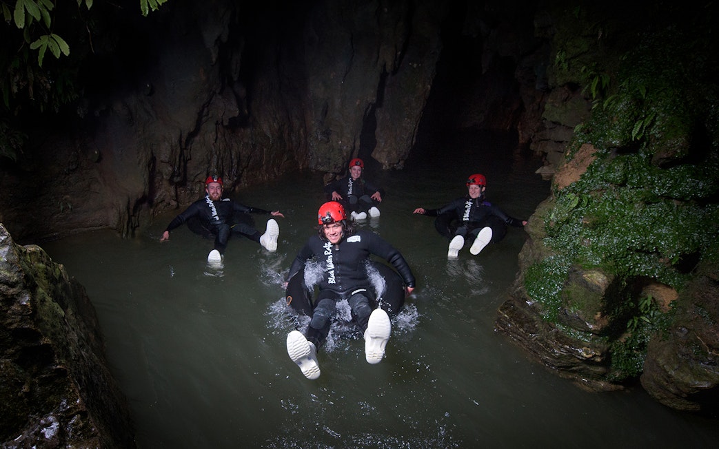 Adventurers black water rafting in a cave during a guided experience in Waitomo.