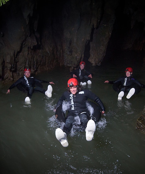 Adventurers black water rafting in a cave during a guided experience in Waitomo.