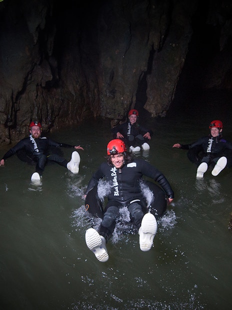 Adventurers black water rafting in a cave during a guided experience in Waitomo.
