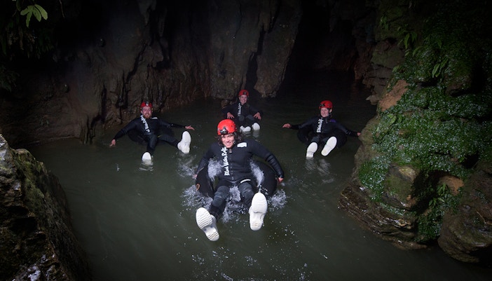 Adventurers black water rafting in a cave during a guided experience in Waitomo.