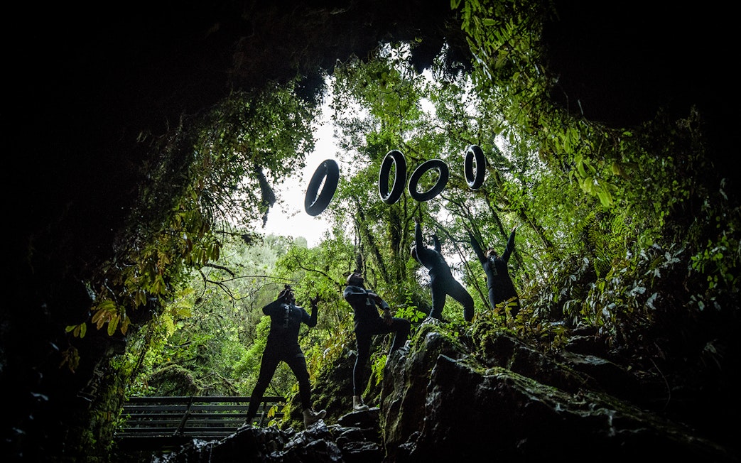 Adventurers in wetsuits prepare for black water rafting in Waitomo cave.