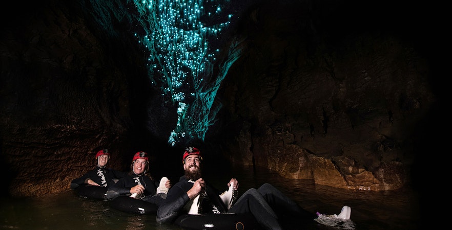Adventurers tubing under glowworms in Waitomo cave during Black Water Rafting experience.