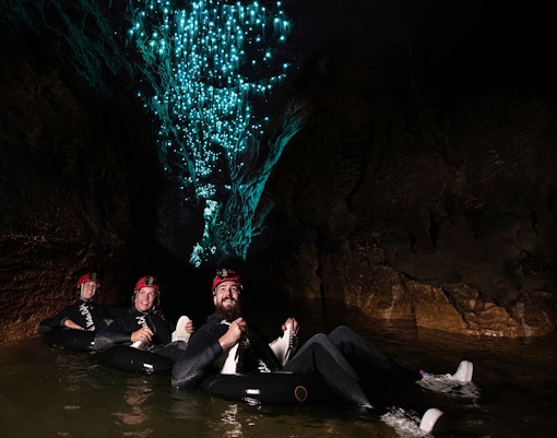 Adventurers tubing under glowworms in Waitomo cave during Black Water Rafting experience.