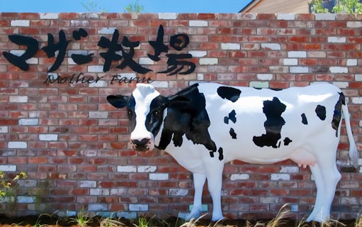 Cow statue in front of Mother Farm sign, Japan.