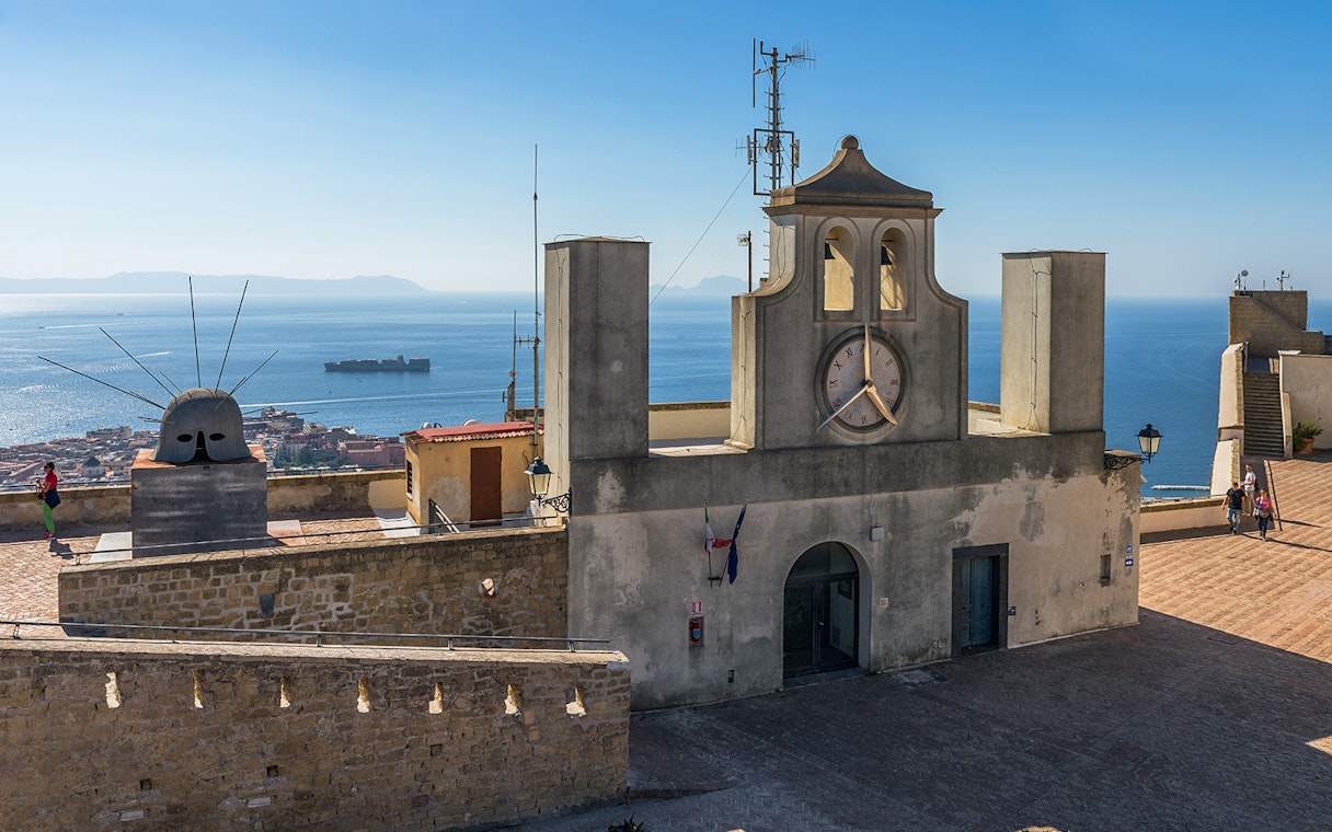 Castel Sant'Elmo terrace with clock tower and sea view, Naples, Italy.