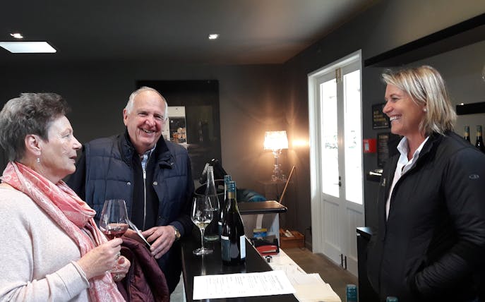 Guests enjoying a wine tasting at a Martinborough winery during a full-day tour from Wellington.