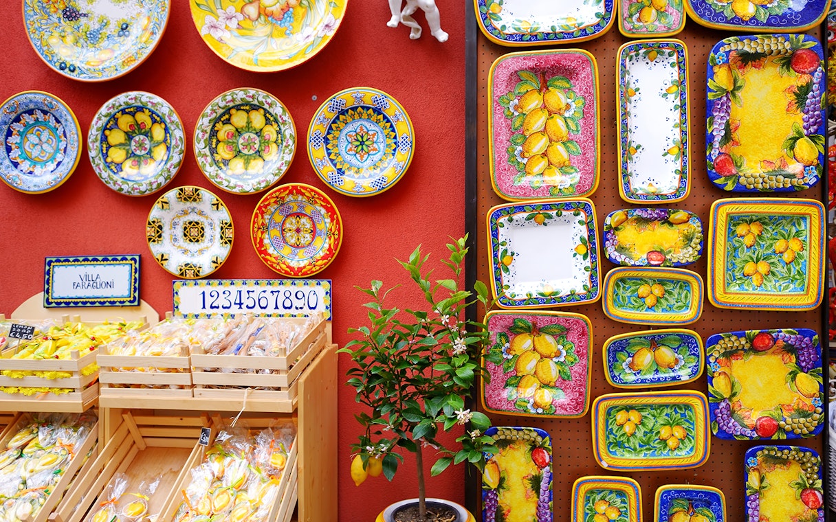 Colorful ceramic plates and lemon-themed pottery on display in Sorrento shop.